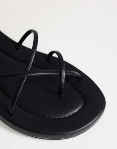 Model wearing Emma strappy flat sandal in black