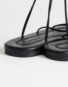 Model wearing Emma strappy flat sandal in black