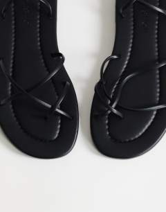 Model wearing Emma strappy flat sandal in black