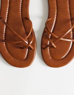 Model wearing Emma strappy flat sandal in tan