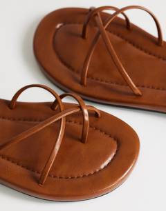 Model wearing Emma strappy flat sandal in tan