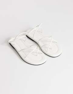 Model wearing Emma strappy flat sandal in white