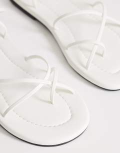 Model wearing Emma strappy flat sandal in white