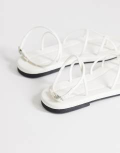 Model wearing Emma strappy flat sandal in white