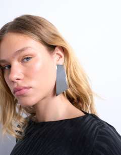 Model wearing Emmey statement stud earrings in silver