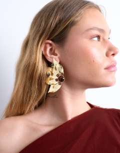 Model wearing Enzo floral statement stud earring in gold