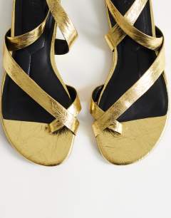 Model wearing Erika flat sandal in gold