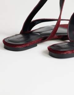 Model wearing Erika flat sandal in red hair on real leather