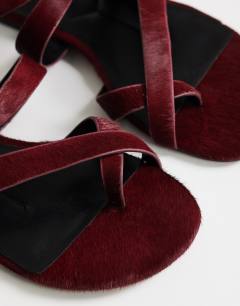 Model wearing Erika flat sandal in red hair on real leather