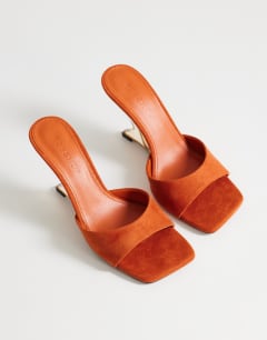 Model wearing Esme mule with clear wedge heel in orange