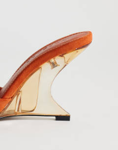 Model wearing Esme mule with clear wedge heel in orange