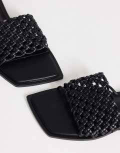 Model wearing Eve woven flat sandal in black