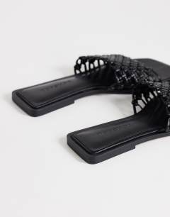 Model wearing Eve woven flat sandal in black