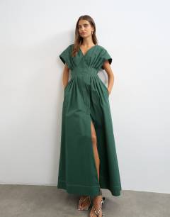 Model wearing Exaggerated shoulder cinched pintucked waist maxi dress in dark green with contrast topstitching