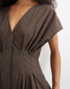 Model wearing Exaggerated shoulder with cinched pintuck waist in chocolate