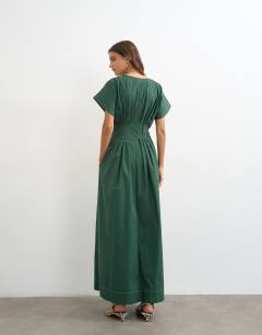 Model wearing Exaggerated shoulder with cinched pintuck waist in dark green with contrast stitch