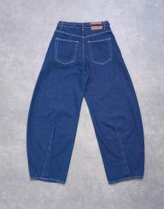 Model wearing Extreme barrel mid rise jean with belt detail in indigo rinse