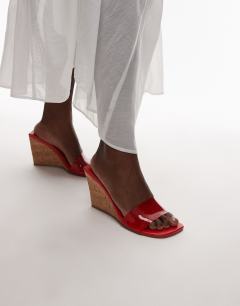 Model wearing Farah high wedge heeled mule in red