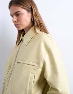 Model wearing Faux bubble leather cropped bomber jacket in buttermilk