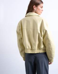 Model wearing Faux bubble leather cropped bomber jacket in buttermilk