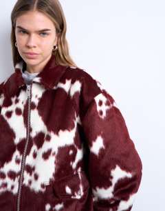Model wearing Faux fur cow print bomber jacket