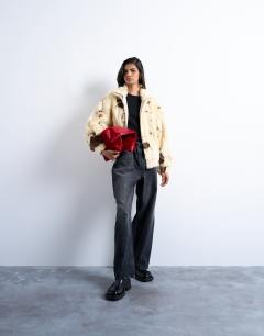 Model wearing Faux fur cow print funnel neck bomber jacket in cream