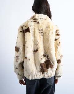 Model wearing Faux fur cow print funnel neck bomber jacket in cream