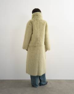 Model wearing Faux fur funnel neck detachable length coat in light green