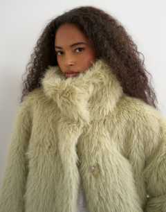 Model wearing Faux fur funnel neck detachable length coat in light green