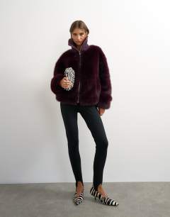 Model wearing Faux fur funnel neck jacket in aubergine