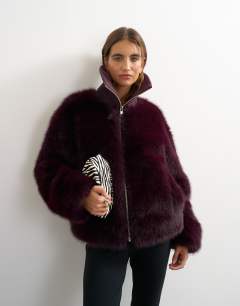 Model wearing Faux fur funnel neck jacket in aubergine