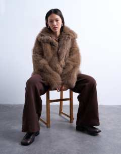 Model wearing Faux fur funnel neck mid length coat in mink