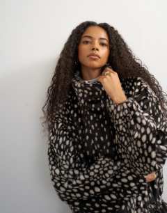 Model wearing Faux fur high neck cinch jacket in brown deer print