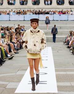 Model wearing Faux fur pony skin cow print funnel neck bomber jacket in cream