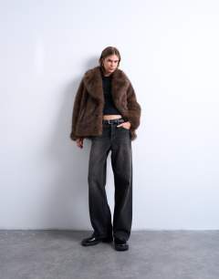 Model wearing Faux fur short jacket with buttons in chocolate