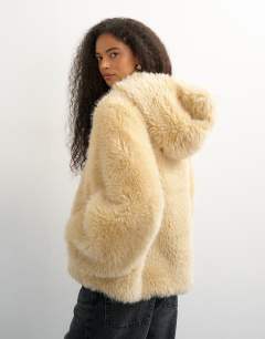 Model wearing Faux fur zip through hooded jacket in cream