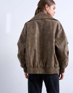 Model wearing Faux leather asymmetric oversized bomber with funnel neck in washed brown 