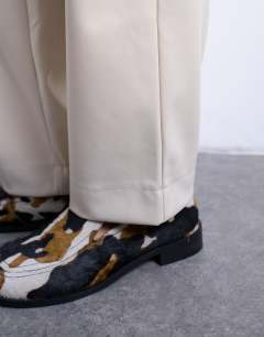 Model wearing Faux leather awkward length pull on trouser in ecru