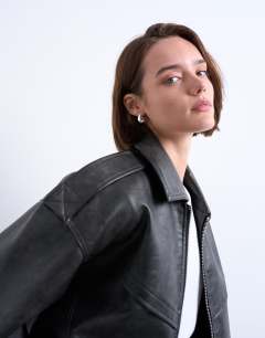 Model wearing Faux leather bubble vintage wash seam detail zip thru bomber jacket in washed black