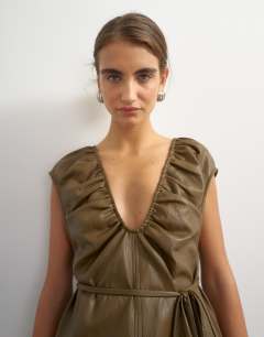 Model wearing Faux leather deep neckline tie detail top in olive