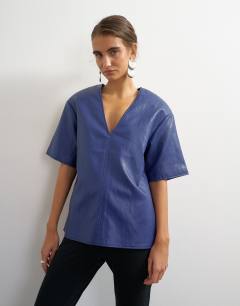 Model wearing Faux leather deep V neckline top in navy