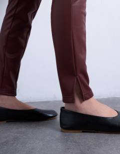 Model wearing Faux leather drain pipe skinny trouser in burgundy