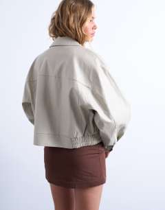 Model wearing Faux leather drop shoulder cropped zip thru jacket in ecru