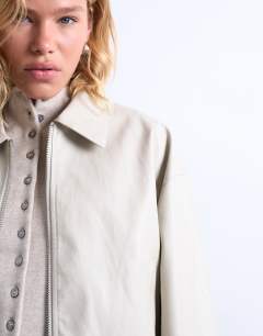 Model wearing Faux leather drop shoulder cropped zip thru jacket in ecru