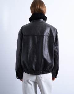 Model wearing Faux leather funnel neck bomber jacket with borg in black