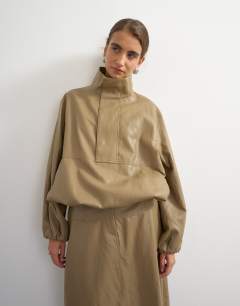Model wearing Faux leather funnel neck bubble hem top in taupe