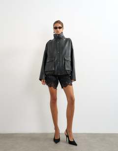 Model wearing Faux leather funnel neck drawstring bomber in black