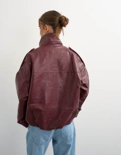 Model wearing Faux leather funnel neck drawstring bomber in burgundy