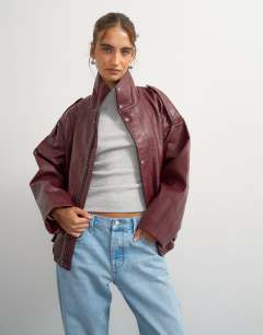 Model wearing Faux leather funnel neck drawstring bomber in burgundy