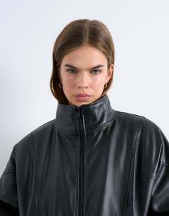 Model wearing Faux leather funnel padded seam detail bomber jacket in black